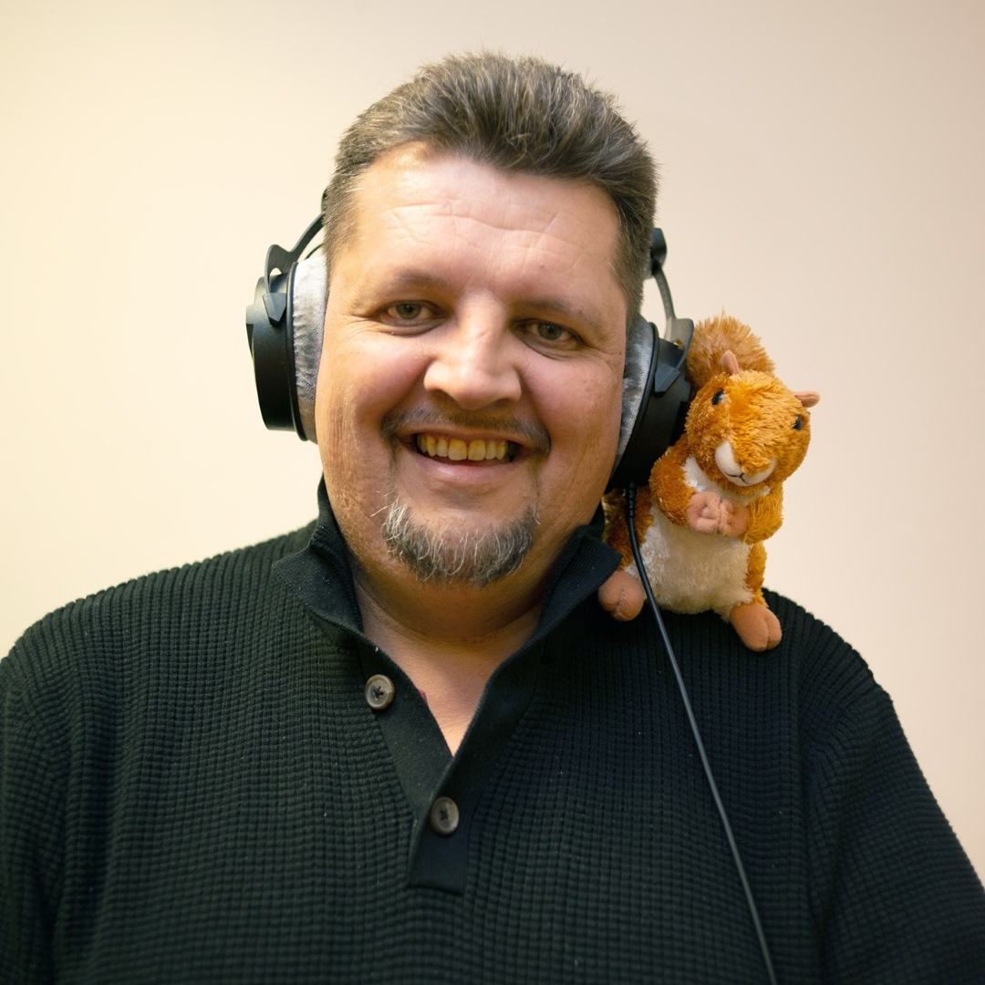 Radio presenter wearing headphones with toy squirrel on shoulder